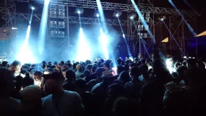 People on a dancefloor with spotlights shining from the DJ area
