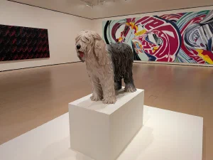 Shaggy sheepdog sculpture on a plinth in a gallery